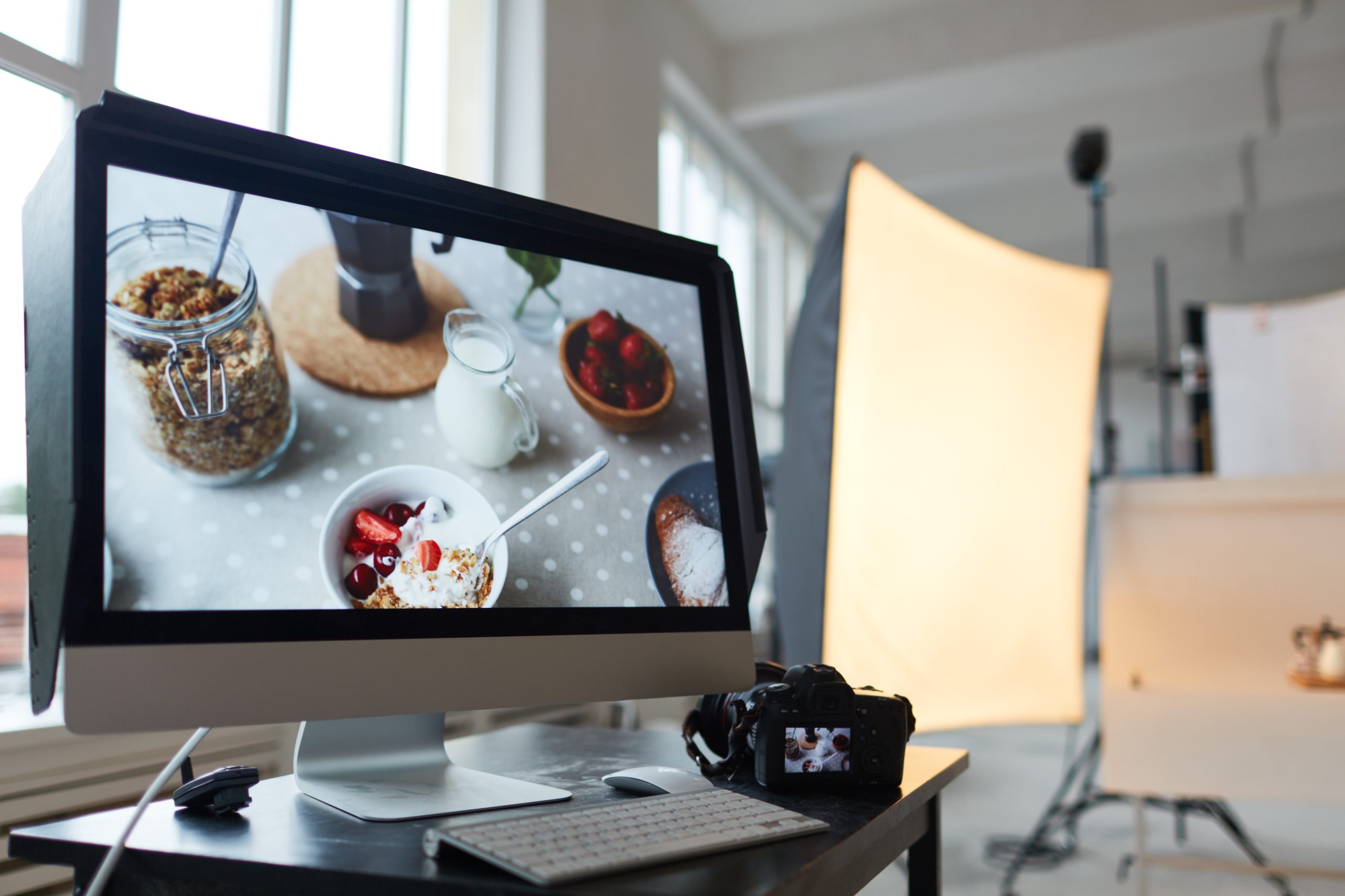 Workplace of photographer with computer monitor and photocamera